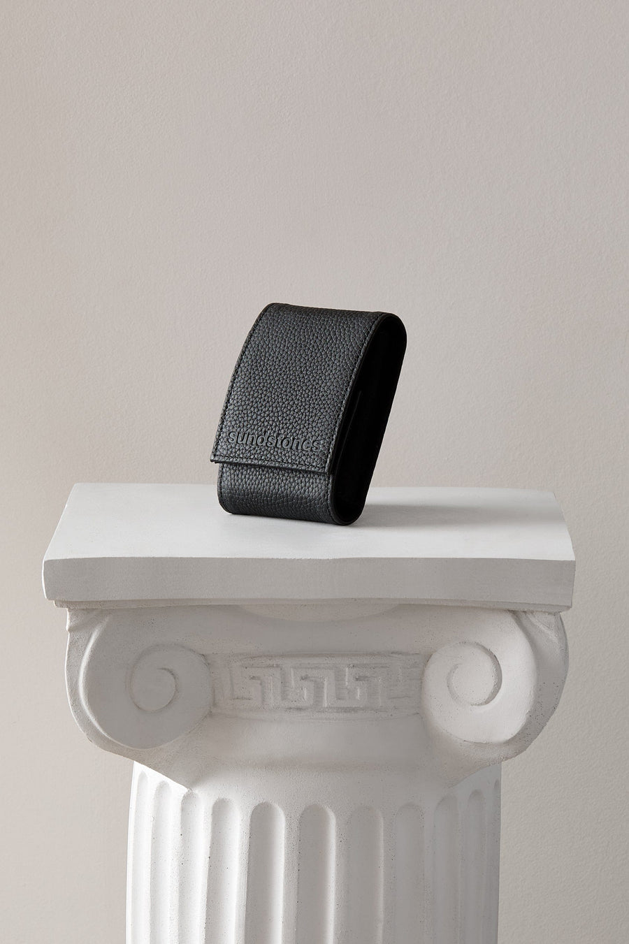 
Arcus Onyx Watch Pouch in black leather standing on a white display column