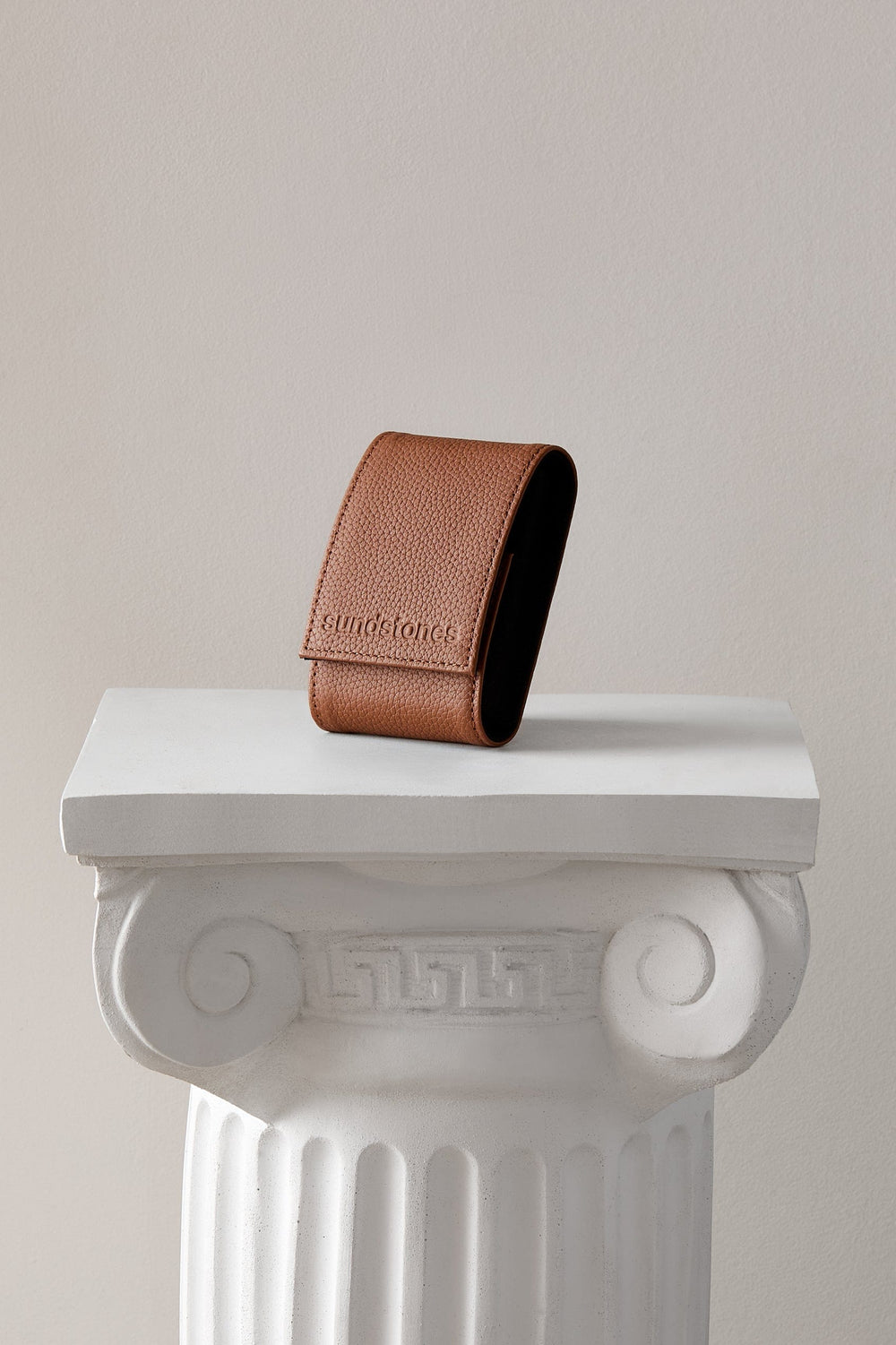 
Arcus Sienna Watch Pouch in brown leather standing on a white display column