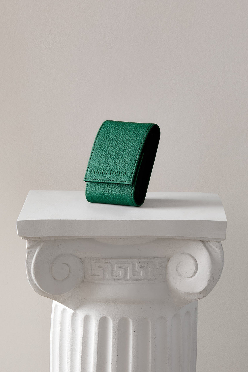 
Arcus Cypress Watch Pouch in green leather standing on a white display column